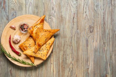Lezzetli Özbek Samsa tabağı ve ahşap arka planda baharatlar