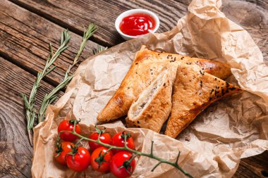 Ahşap zemin üzerinde lezzetli Özbek samsa ve domates sosu