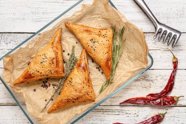 Beyaz ahşap zemin üzerinde lezzetli Özbek samsa tepsisi