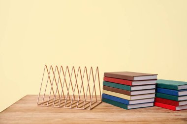 Metal düzenleyici ve kitaplar sarı arkaplanda