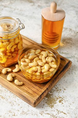 Tatlı kaju fıstığı ve bal arkaplanlı tahta.