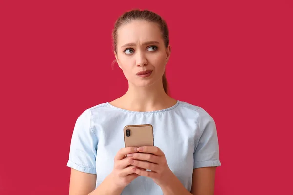 Thoughtful Young Woman Mobile Phone Red Background — Stock Photo, Image