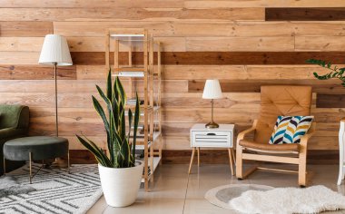 Şık oturma odasının içinde kitap rafları ve koltuk var.