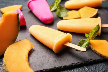 Lezzetli buzlu pano ve koyu arkaplanda kavun parçaları.