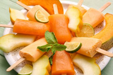 Lezzetli buzlu tabak ve yeşil ahşap arka planda kavun parçaları.