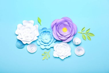 Mavi arka planda el yapımı güzel kağıt çiçekler.