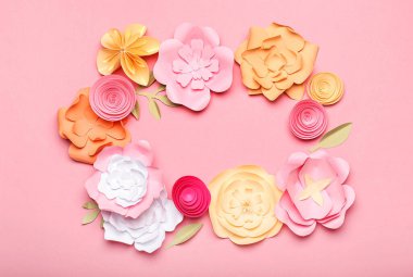 Pembe arka planda el yapımı kağıt çiçeklerden yapılmış güzel bir çerçeve.