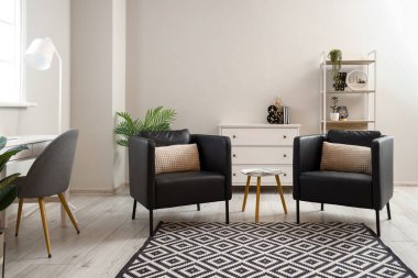 Siyah koltukları ve masası olan modern oturma odası.