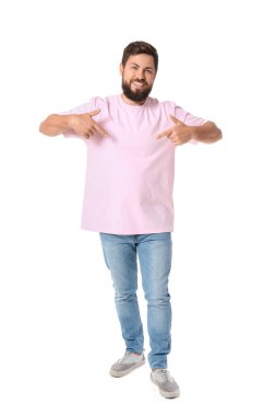 Beyaz arka planda pembe tişörtü gösteren yakışıklı bir adam.