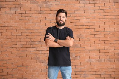 Tuğla arka planda siyah tişörtlü yakışıklı adam