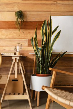 Ahşap masaları ve çiçekleri olan şık bir oda.