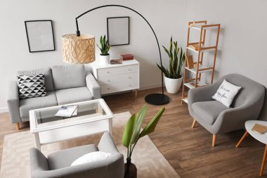 Standart lamba, kanepe ve koltuklu bir oturma odası.