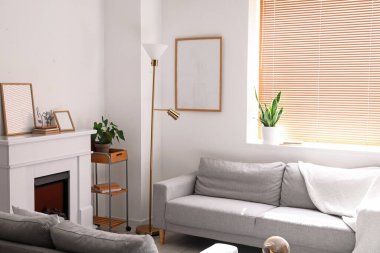 Lambalı, kanepeli ve şömineli bir oturma odası.