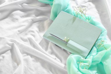 Hafif kumaş arka planında gypthe çiçekleri olan şık bir defter.