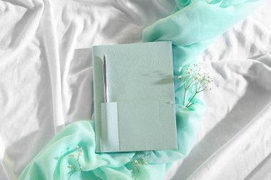 Hafif kumaş arka planında gypthe çiçekleri olan şık bir defter.