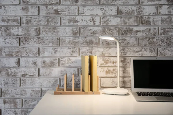 Wooden Organizer Books Glowing Lamp Table Brick Wall — Stock Photo, Image