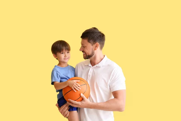 Jovem Com Seu Filho Bola Fundo Amarelo — Fotografia de Stock