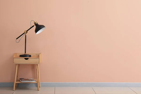 Holztisch Mit Schwarzer Lampe Nahe Beiger Wand — Stockfoto