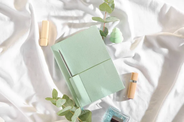 Stylish Notebook Eucalyptus Lipsticks Perfume White Fabric Background — Stock Photo, Image