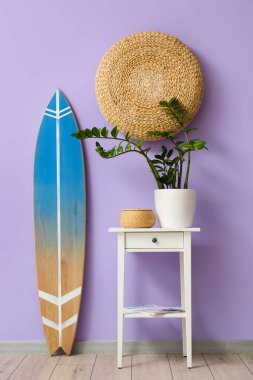 Sörf tahtası ve renkli duvarın yanındaki masa.