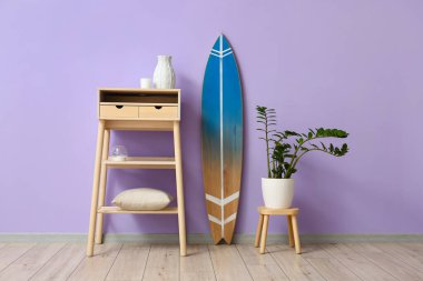 Sörf tahtası, masa ve duvar kenarındaki tabure.