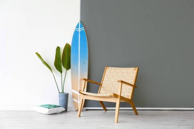 Sörf tahtası, koltuk ve duvarın yanındaki bitki örtüsü.