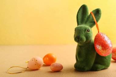 Tatlı Paskalya tavşanı ve renkli arka planda boyanmış yumurtalar.