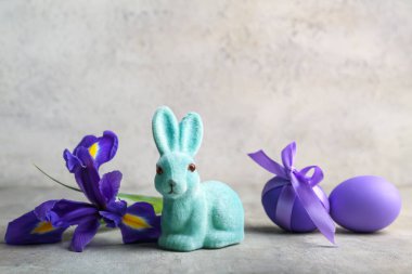 Renkli yumurta ve çiçekli şirin Paskalya tavşanı.