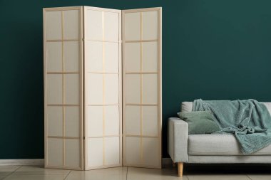 Kaliteli katlama ekran ve oda duvarının yanındaki kanepe.