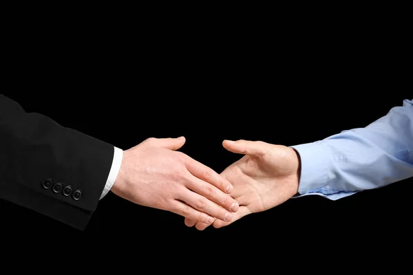 黒を背景に握手を交わすビジネスパートナー — ストック写真