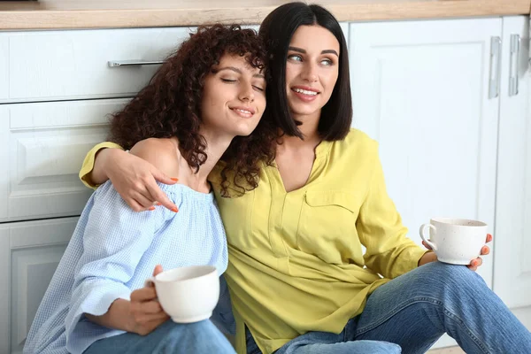 Hermosas Hermanas Sonrientes Sosteniendo Tazas Con Abrazándose Cocina — Foto de Stock