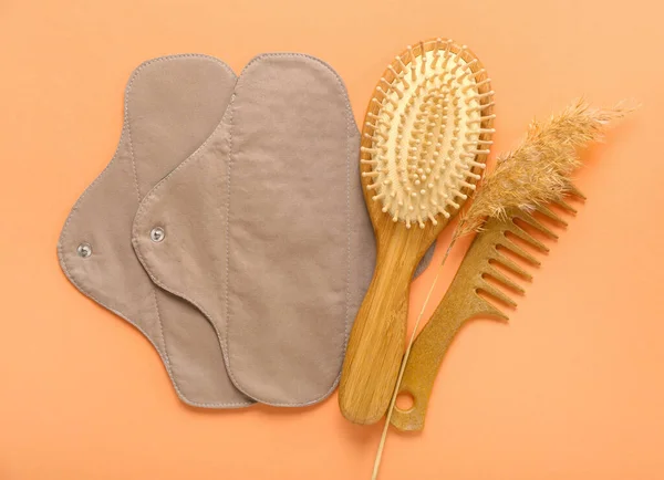 Herbruikbare Menstruatiepads Haarborstels Oranje Achtergrond — Stockfoto