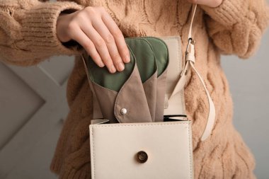 Tekrar kullanılabilir adet pedlerini açık arkaplana koyan kadın