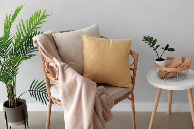 Yastıklı, ekoseli ve ışıklı duvarlı hasır sandalye.