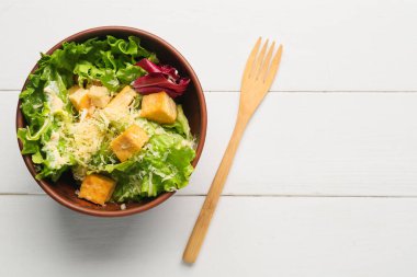 Hafif ahşap arka planda lezzetli vejetaryen Sezar salatası.