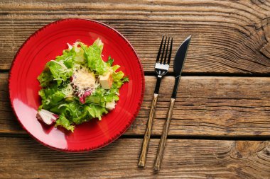 Ahşap arka planda lezzetli vegan Sezar salatası tabağı.