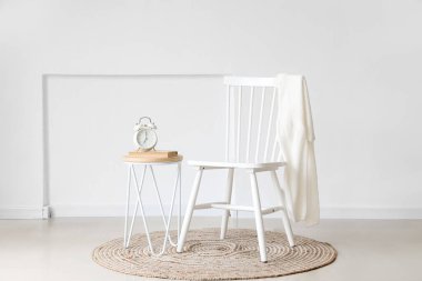 Çalar saati, kitapları ve koltuğu olan modern bir masa.