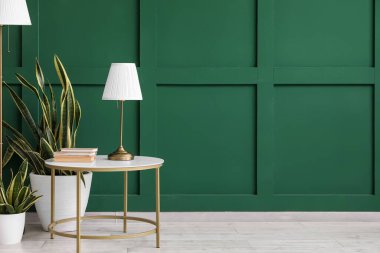 Kitapları, çiçekleri ve lambası olan modern masa.