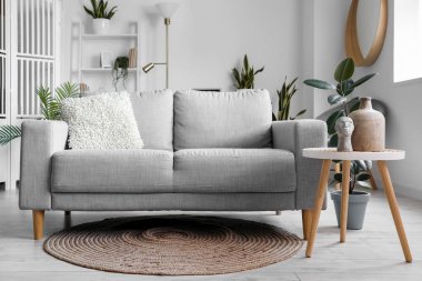 Odanın içinde çiçek ve kanepe olan modern bir masa.