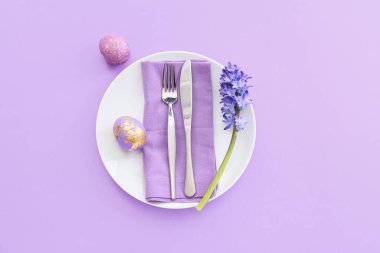 Paskalya yumurtaları ve leylak arkaplanda çiçeklerle güzel bir masa.