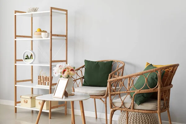 快適な椅子 写真フレーム付きのテーブルと部屋のインテリアの花 — ストック写真