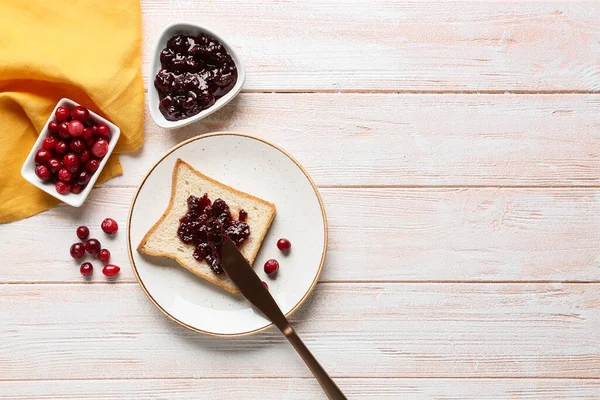 Spreading Tasty Lingonberry Jam Toast Knife Light Wooden Background — Stock Photo, Image