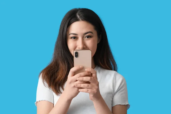 Krásná Mladá Asijská Žena Mobilním Telefonem Modrém Pozadí — Stock fotografie