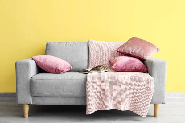 Stylish Sofa Book Yellow Wall — Stock Photo, Image