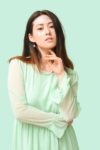 Giovane Donna Asiatica Con Glitter Trucco Toccare Mento Sfondo Colore — Foto Stock