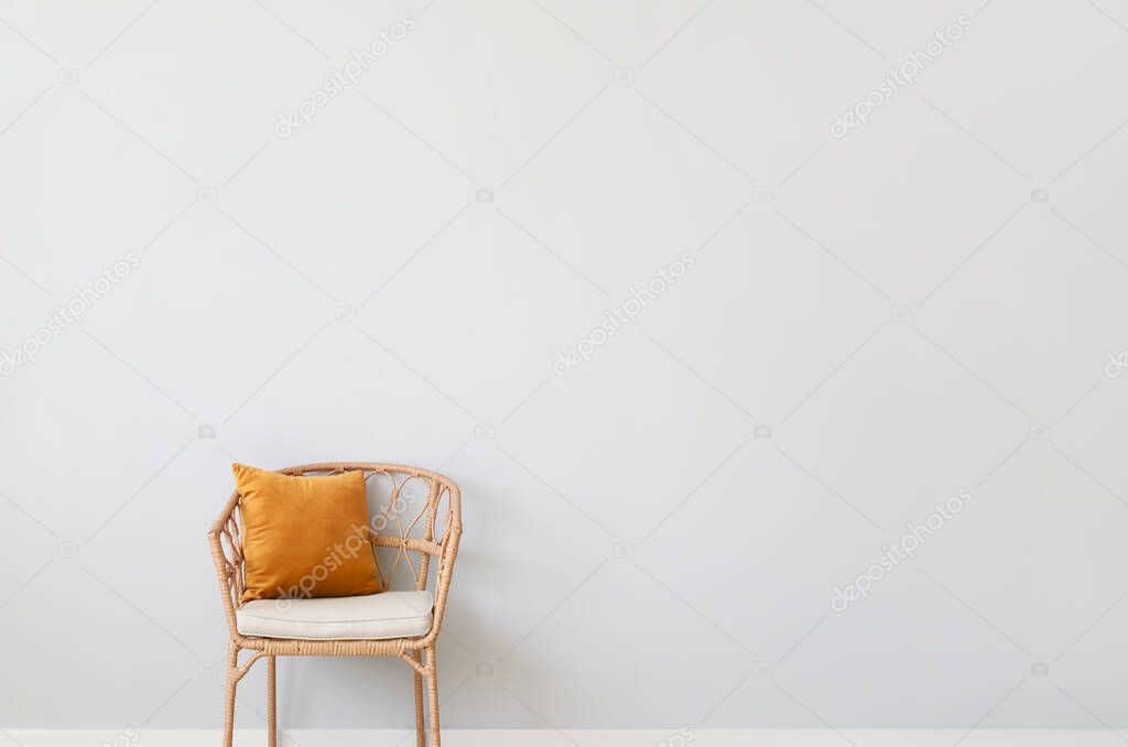 Wicker chair near light wall in room