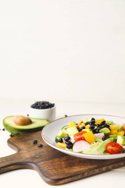 Hafif ahşap masada Meksika sebze salatası tabağı.