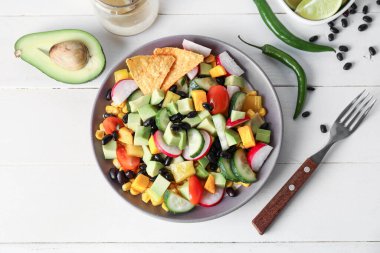 Bir kase Meksika sebze salatası ve hafif ahşap arka planda malzemeler
