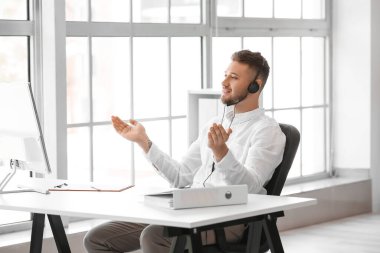 Ofiste bilgisayarla çalışan çağrı merkezinin yakışıklı danışmanı.