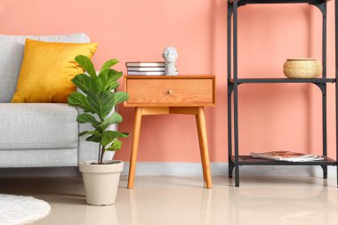 Şık oturma odasında kitap ve dekor olan ahşap bir masa.